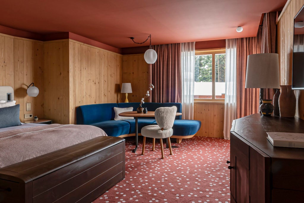 Luxurious deluxe junior suite at Le Coucou Méribel, featuring alpine-inspired design with warm wood tones and elegant contemporary furnishings