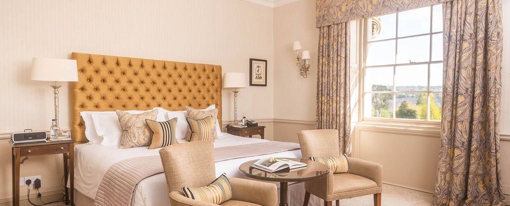 Elegant heritage room at Royal Crescent Hotel, Bath, with antique furniture, soft cream walls, and period-style four-poster bed overlooking historic landscape