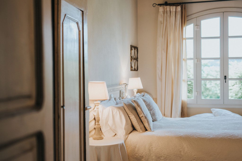 Elegant deluxe double room at scenic Italian hotel with plush white bedding, modern furnishings, and soft natural lighting near picturesque window view