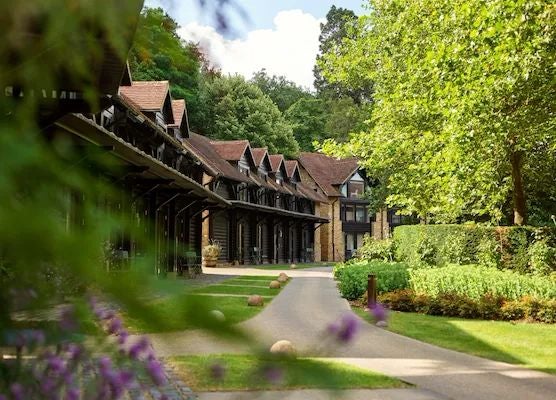 Luxurious countryside estate with manicured gardens, elegant stone manor, and lush green landscape at an exclusive UK hotel retreat