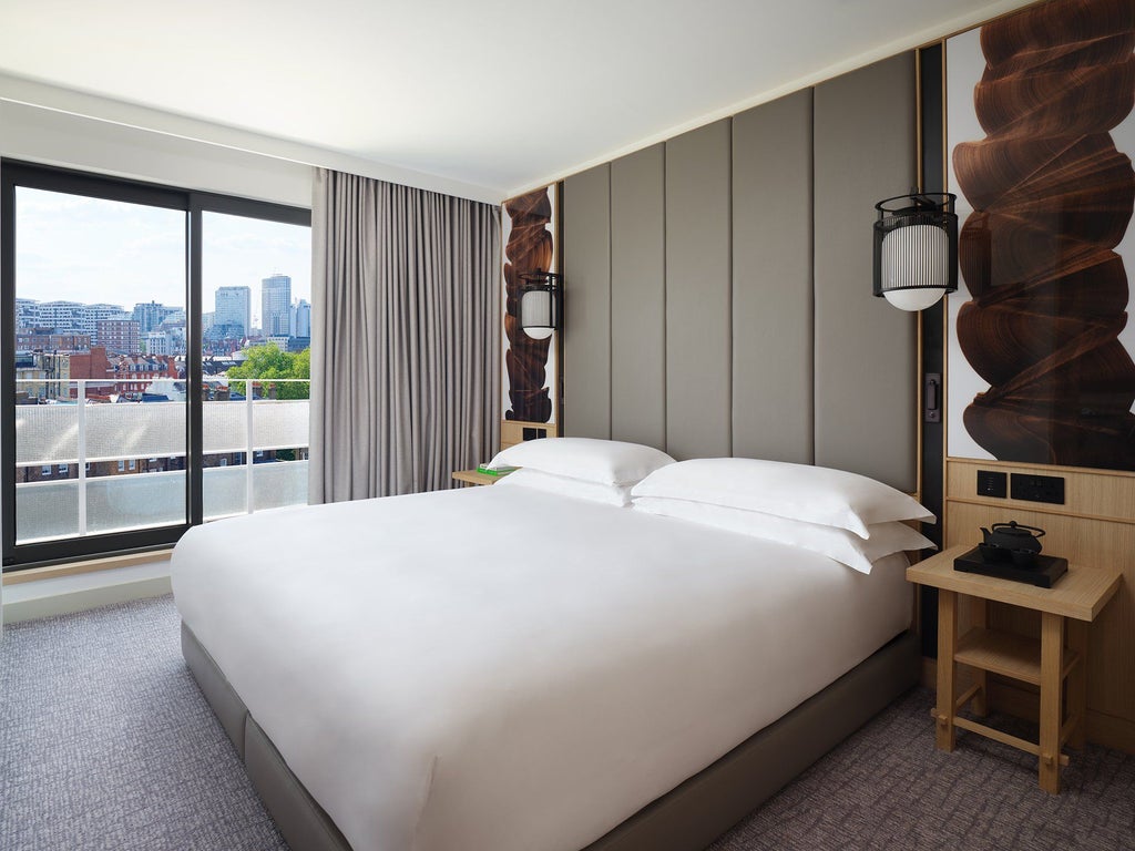 Modern luxury hotel room with contemporary design, soft neutral tones, king-size bed, floor-to-ceiling windows, and private balcony overlooking urban landscape at Scenset Hotel London Portman Square