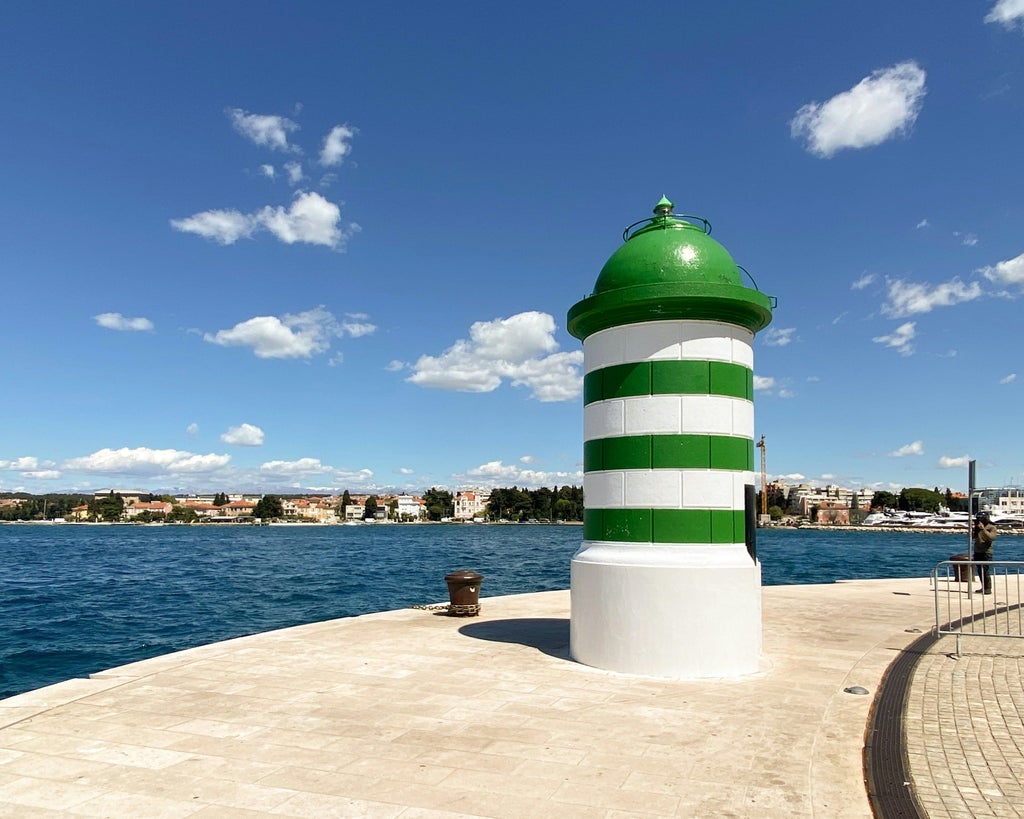 Historic cobblestone streets and marble buildings of Zadar's Old Town lead to waterfront with unique Sea Organ and sunset vie