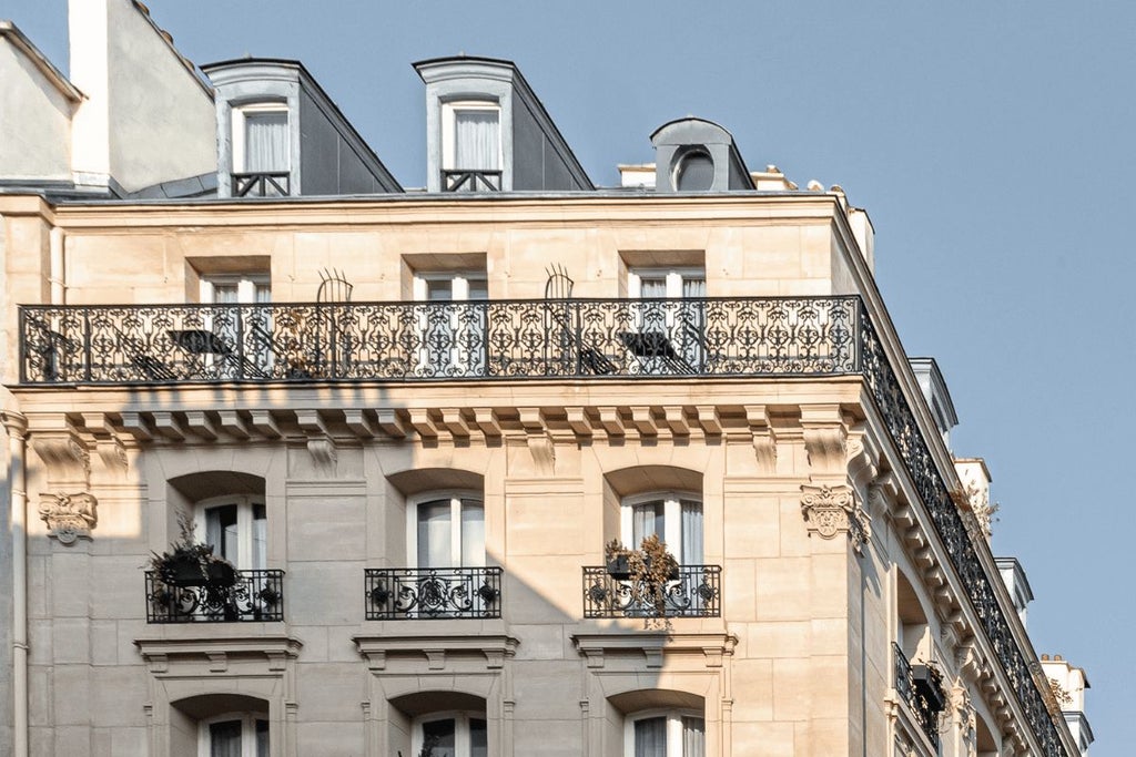 Luxurious boutique hotel facade in Paris' vibrant Pigalle district, featuring elegant French architectural details and warm, inviting street-level ambiance