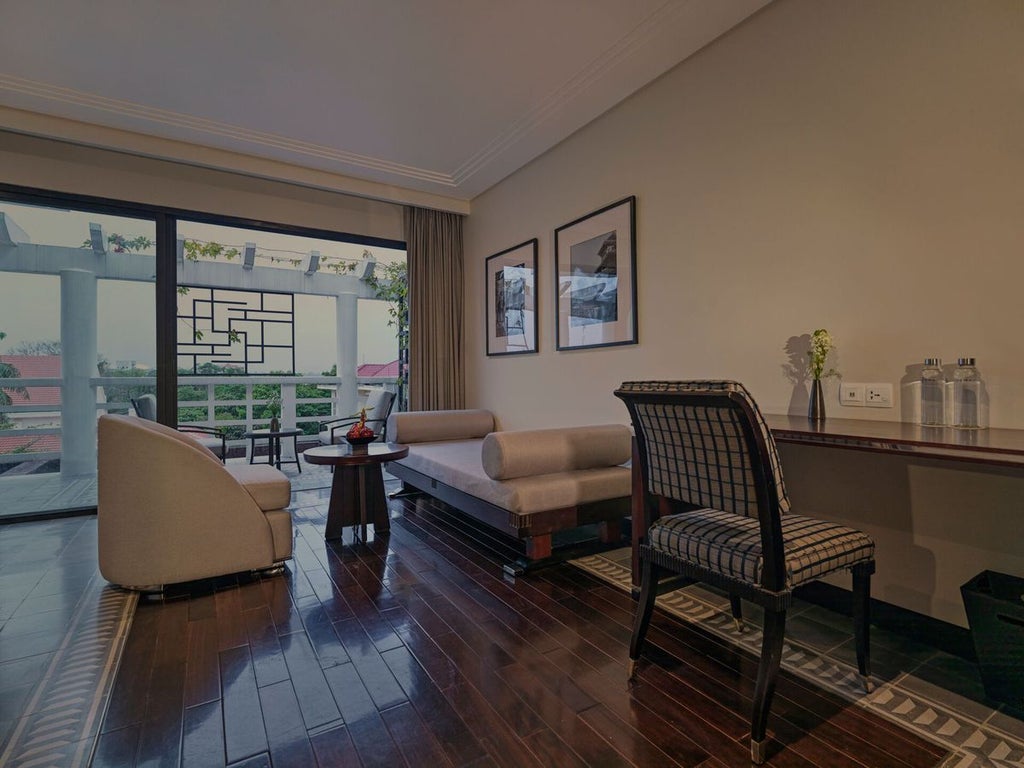 Elegant Deluxe Room at Azerai La Residence in Hue, Vietnam, featuring colonial-inspired decor, crisp white linens, and traditional wooden furnishings