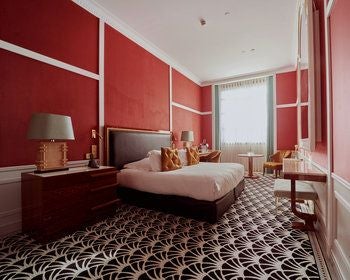 Elegant suite with ornate gold-framed mirror, plush cream armchair, and luxurious king bed at Maison Albar Hotel's Monumental Palace in scenic Portugal