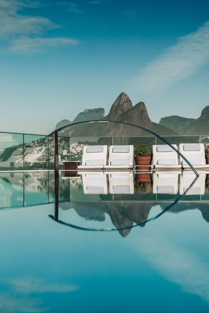 Elegant Art Deco hotel nestled in Rio de Janeiro, overlooking Ipanema Beach with modern white facade, sleek architectural design, and panoramic ocean views.