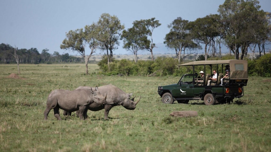 Luxury safari tent overlooking vast Kenyan savanna, with golden grasslands and acacia trees, wild animals grazing in distant landscape