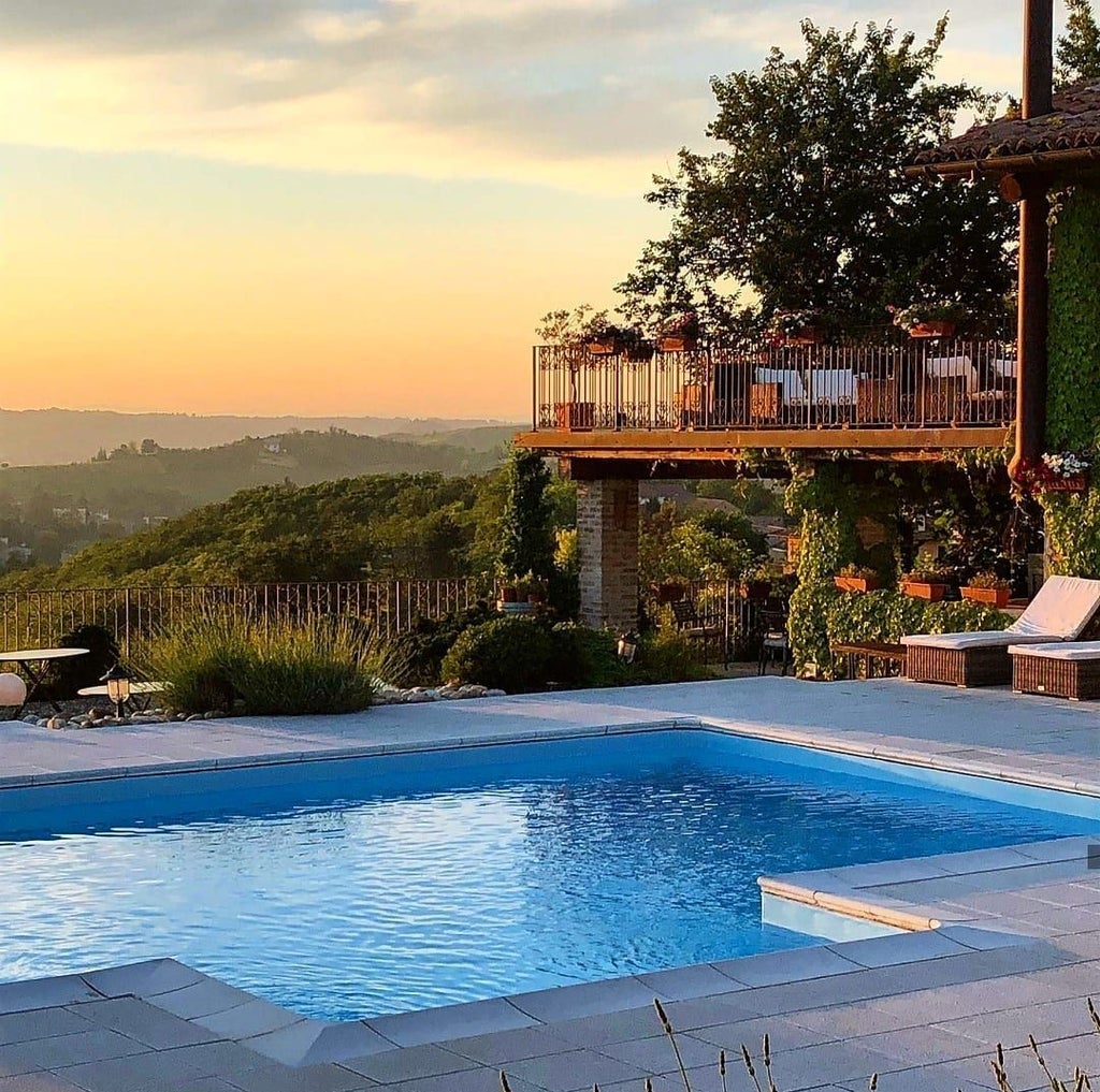 Elegant Mediterranean villa-style hotel nestled in scenic Italian landscape, with stone facade, lush gardens, and terracotta roof against azure sky