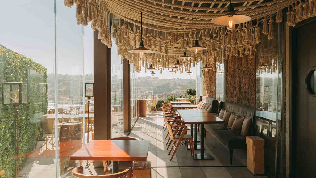 Luxurious poolside terrace at Torel Avantgarde hotel overlooking Porto cityscape, with infinity pool edge and modern lounge chairs