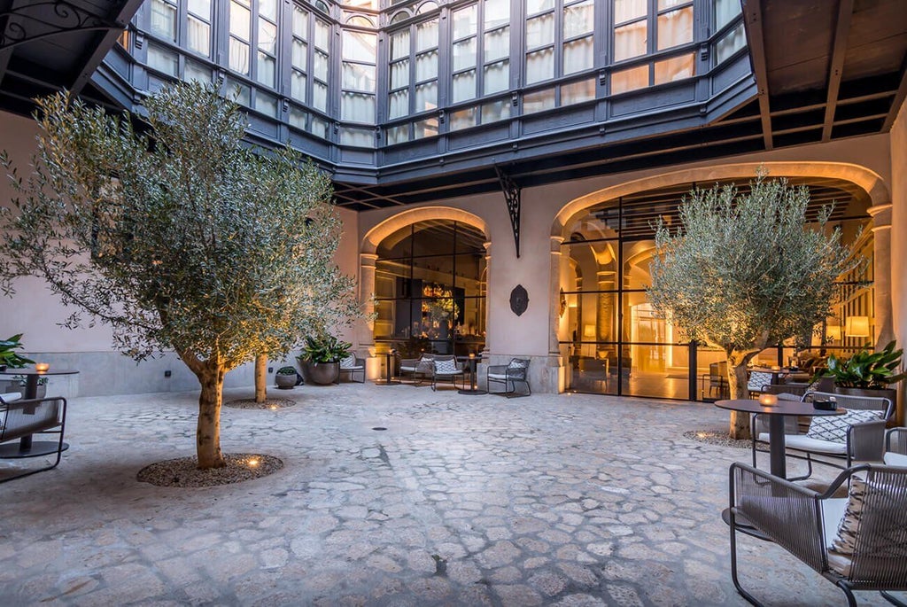 Elegant boutique hotel in Palma de Mallorca with neoclassical architecture, stone facade, and ornate balconies reflecting Spanish luxury design