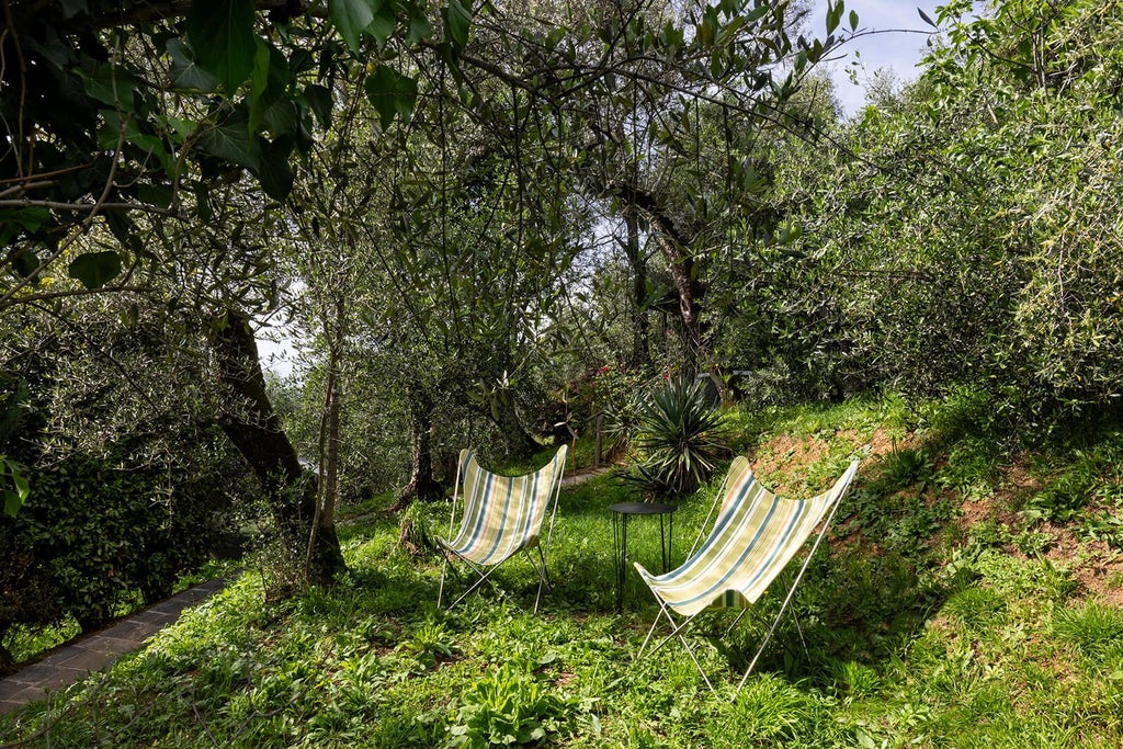 Elegant Tuscan countryside boutique hotel with rustic stone exterior, surrounded by rolling green hills and cypress trees at sunset