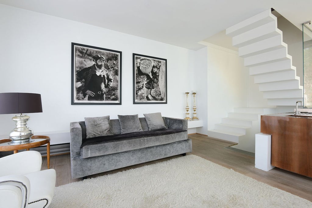 Minimalist Italian loft suite with exposed wood beams, modern furnishings, large windows overlooking Florentine landscape, blending rustic charm and contemporary design elegance