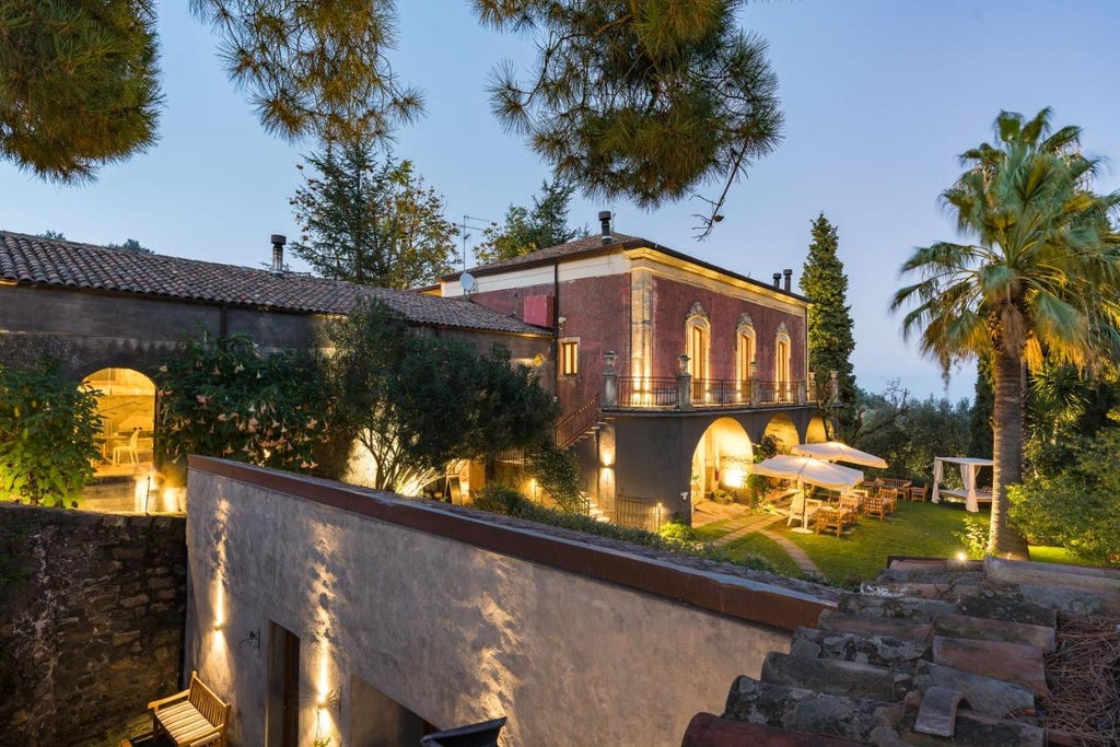 Elegant Sicilian boutique hotel nestled on Mount Etna's slopes, featuring historic stone buildings amid lush vineyards and gardens