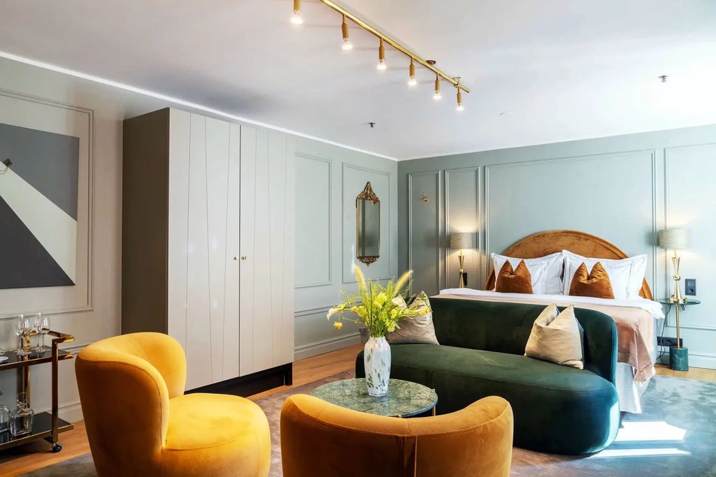 Elegant deluxe hotel room at scenset's Berns Hotel in Sweden, featuring sophisticated modern decor, plush bedding, and refined architectural details