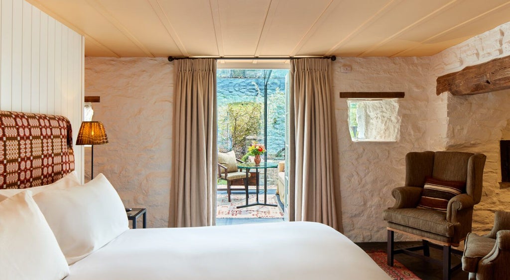 Elegant boutique hotel room with soft neutral tones, plush bedding, and tasteful artwork, showcasing refined country house luxury at Grove of Narberth