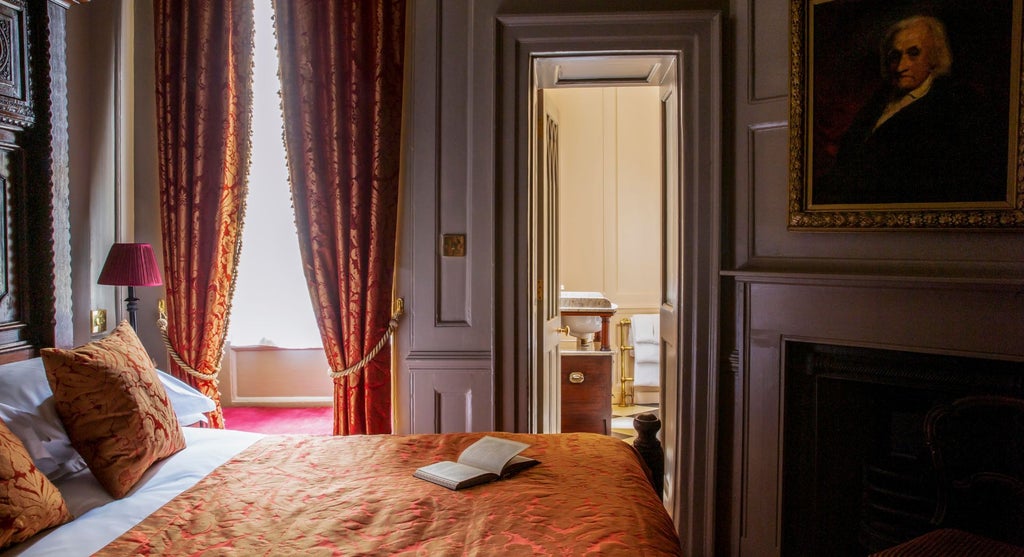 Elegant club double room with plush cream-colored bedding, dark wood furnishings, and classic British decor at luxurious Scenset hotel in United Kingdom