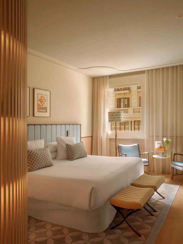 Elegant superior hotel room with modern minimalist design, crisp white linens, warm wood accents, and panoramic city view in downtown Barcelona hotel