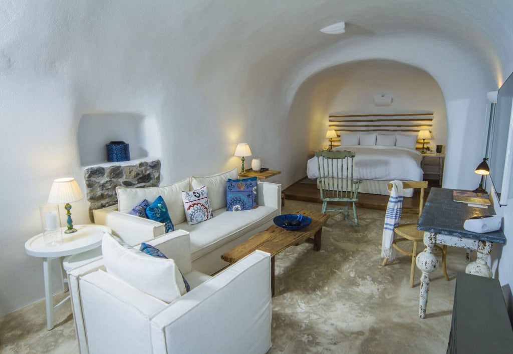 Elegant white-washed cave suite with panoramic Aegean Sea view, minimalist Cycladic design, and private terrace overlooking Santorini's iconic blue-domed landscape