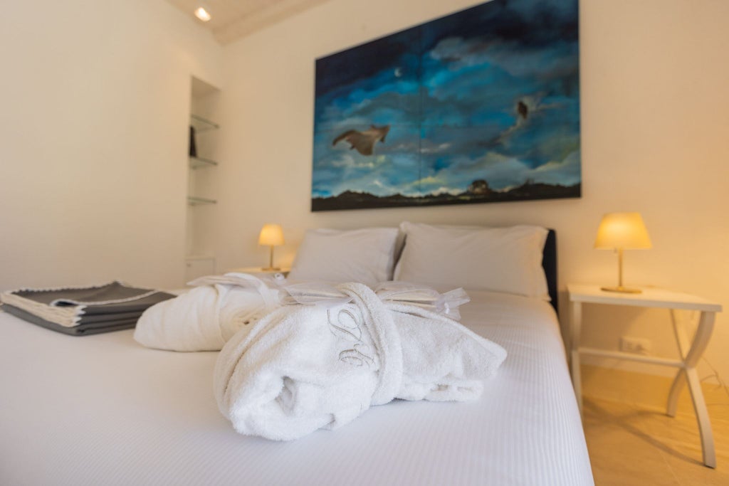 Elegant Sicilian luxury suite with soft cream walls, ornate four-poster bed, traditional ceramic tiles, and warm natural sunlight streaming through arched windows