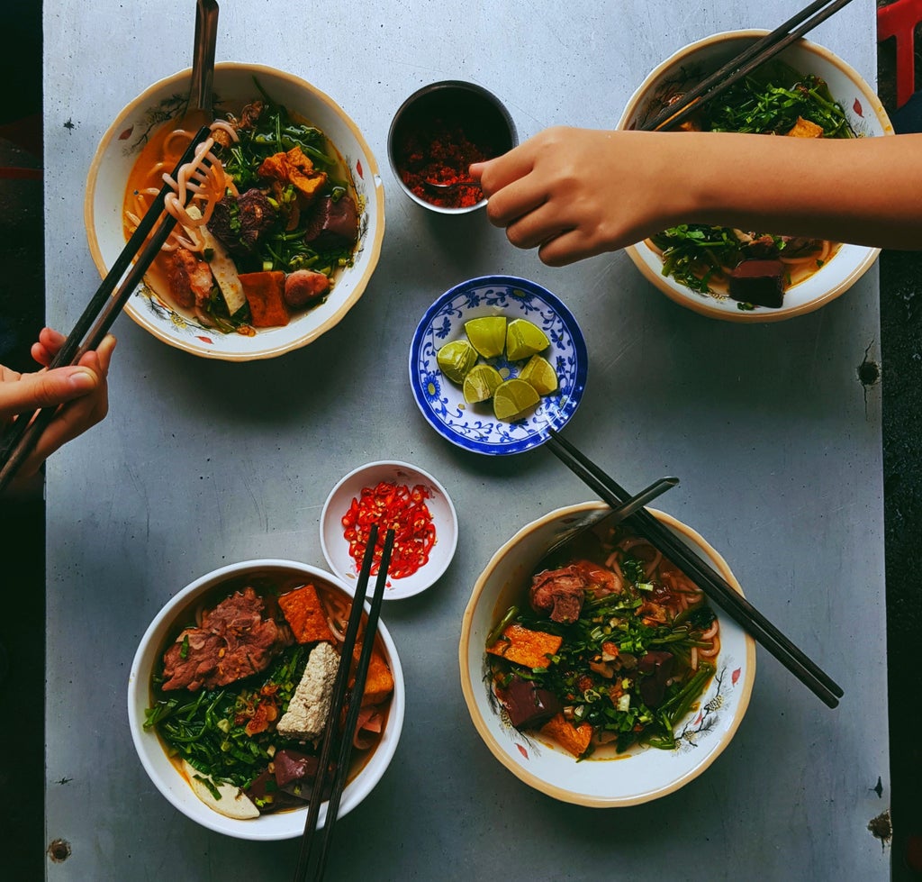 Skilled Vietnamese chef preparing fresh ingredients in a vibrant Hoi An kitchen, showcasing traditional cooking techniques and local culinary artistry