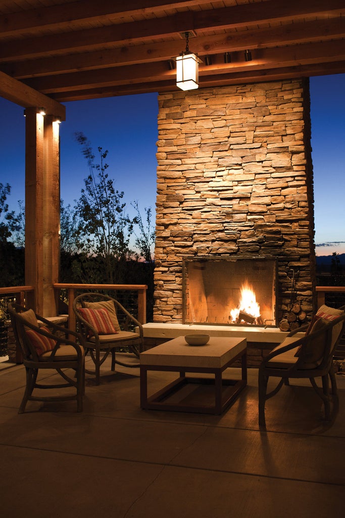 Adobe-style luxury resort with tan stucco walls, wooden beams, and private balconies nestled against Santa Fe mountains at sunset