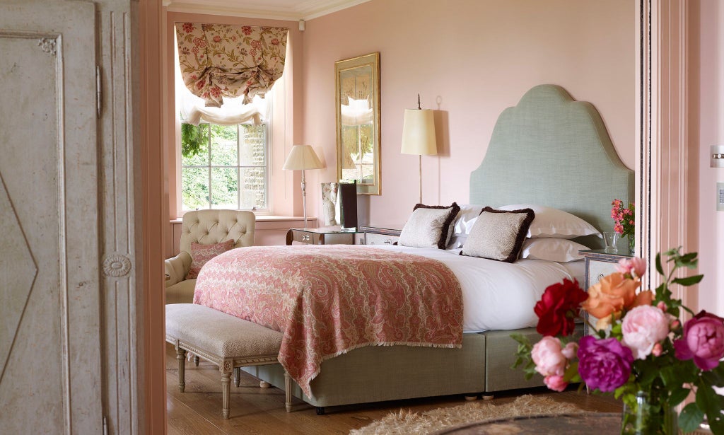 Luxurious hotel room with elegant English rose-themed decor, soft cedar accents, plush white bedding, and refined neutral color palette in UK setting