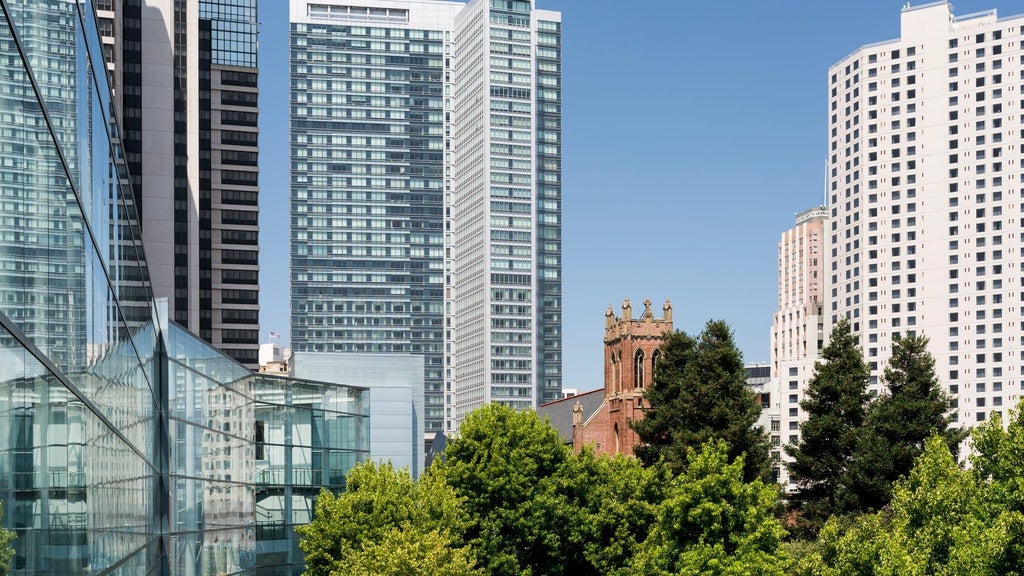 Luxurious four-star hotel with sleek modern architecture overlooking San Francisco skyline, featuring elegant glass facade and sophisticated urban design