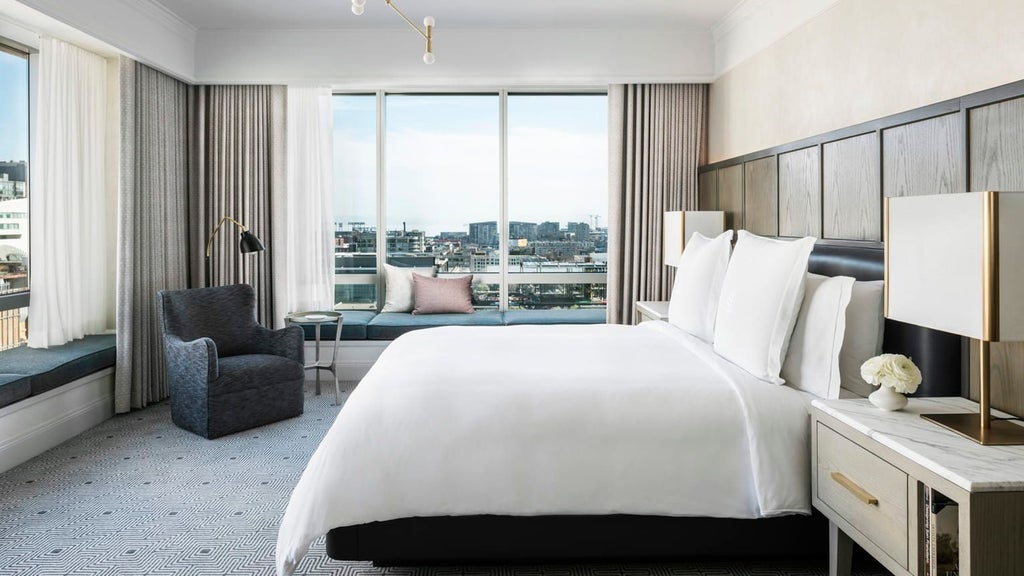 Luxurious premier suite at a high-end downtown hotel with modern decor, plush king bed, panoramic city views, and elegant neutral color palette