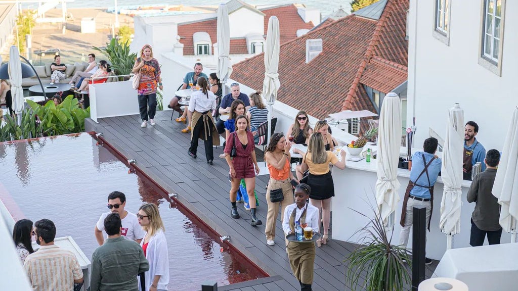 Boutique hotel overlooking Lisbon's historic Alfama district, featuring traditional terracotta rooftops, whitewashed walls, and a charming outdoor terrace with panoramic city views