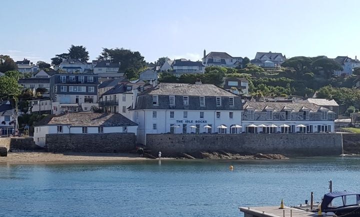 Luxurious deluxe seaview room at a coastal UK hotel, featuring crisp white linens, elegant nautical decor, and panoramic ocean views through large windows.