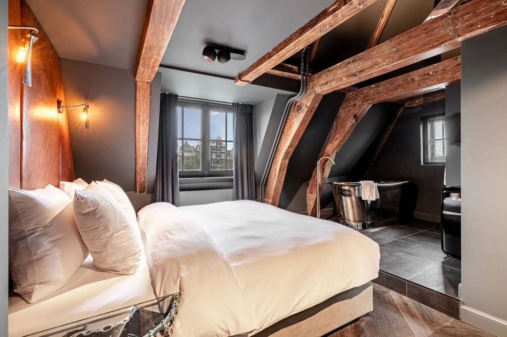 Historic boutique hotel in Amsterdam with classic Dutch architecture, featuring ornate brickwork and large windows overlooking the canal