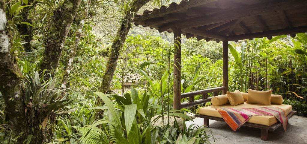 Luxurious stone and wood bungalows nestled in cloud forest, with lush gardens and mountain views at Machu Picchu's base