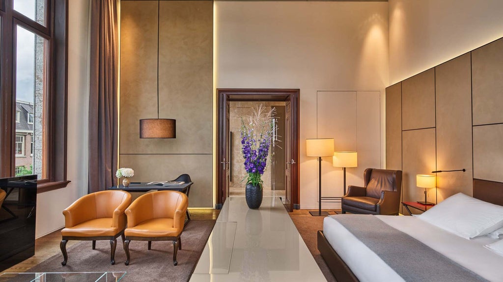 Luxurious Van Baerle Suite at Conservatorium Hotel, featuring elegant design, warm wood tones, modern furnishings, and expansive city views of Amsterdam.