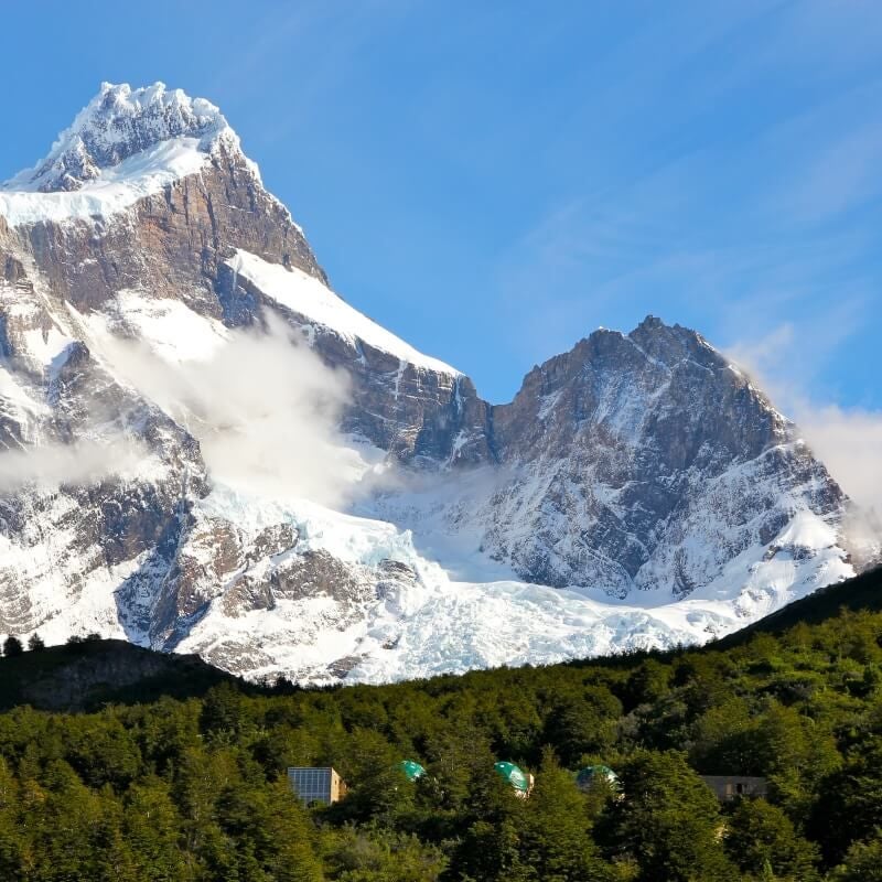 Panoramic view of luxurious eco-lodge nestled in rugged Patagonian landscape, with snow-capped mountains and pristine wilderness surrounding modern architectural design