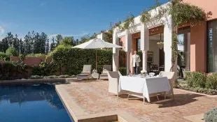 Spacious Moroccan presidential villa with private infinity pool, terracotta tiles, lush gardens, and traditional architectural elements at luxury resort