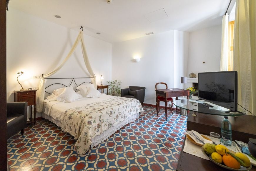 Elegant bedroom with soft white linens, rustic wooden headboard, and panoramic view of Spanish countryside at Ca's Xorc Luxury Retreat, Mallorca