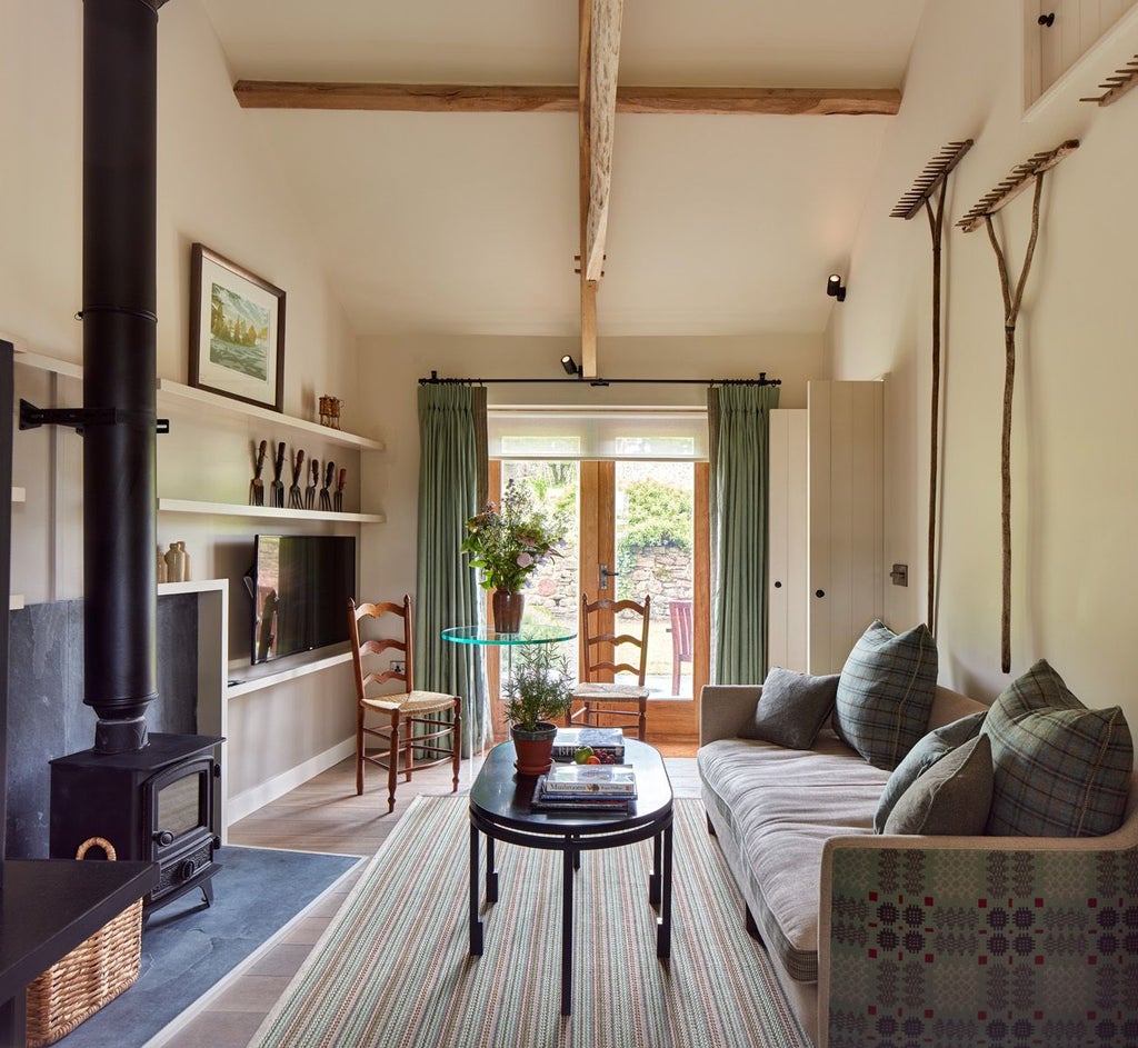 Elegant rustic-chic bedroom at Grove of Narberth hotel, featuring soft neutral tones, luxurious linens, and traditional Welsh countryside views through large windows