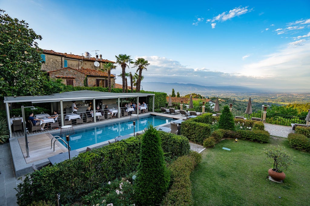 Luxurious Italian countryside villa with stone facade, terracotta roof, rolling Tuscan hills, and manicured gardens bathed in golden afternoon sunlight