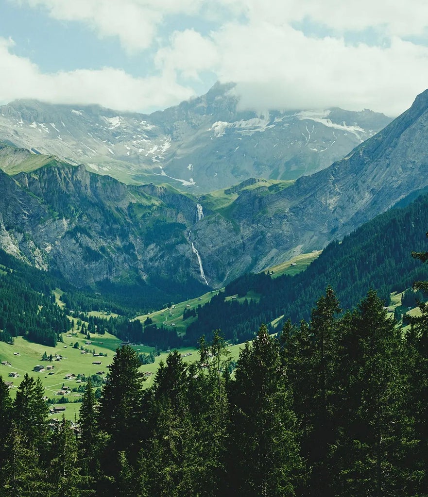 Luxurious alpine hotel with sleek modern design, panoramic mountain views of Swiss Alps, minimalist wooden exterior blending seamlessly with snow-capped landscape