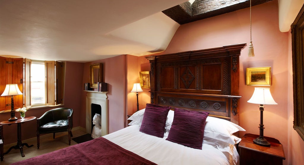 Elegant club double room with plush bedding, rich wooden accents, soft ambient lighting, and sophisticated contemporary UK hotel design