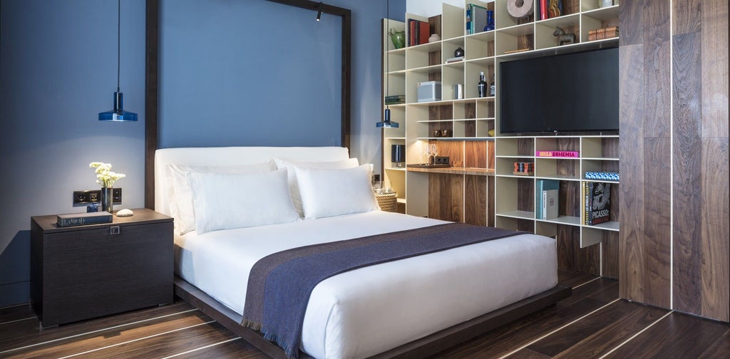 Luxurious white-themed deluxe hotel room with modern minimalist design, elegant wood accents, and floor-to-ceiling windows overlooking urban landscape in Spain