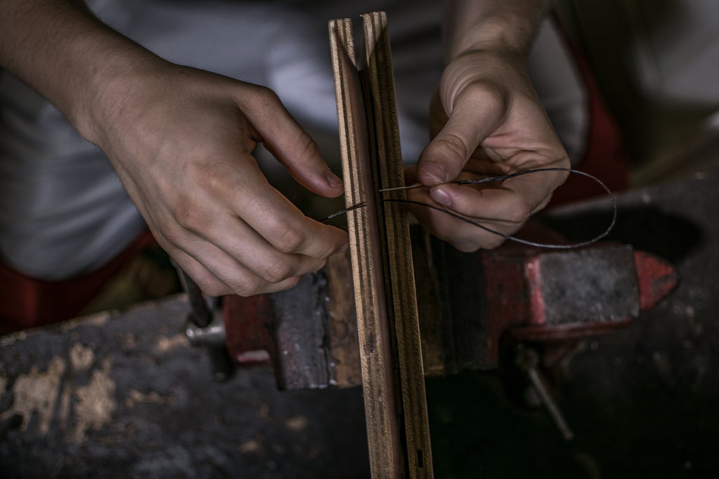 Local jewelry artisan in Florence workshop showcases handcrafted gold pieces while explaining traditional metalworking techniques