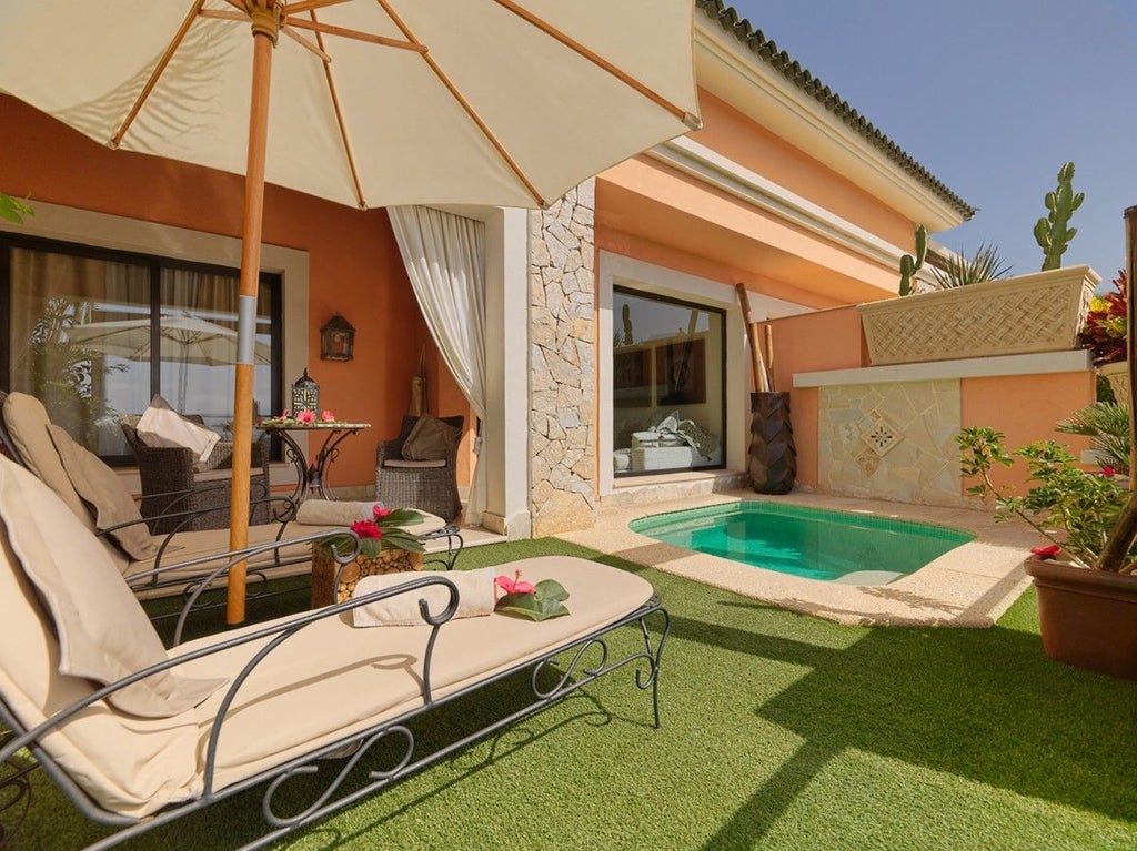 Elegant Mediterranean villa with infinity pool overlooking lush gardens, featuring white stone architecture and palm-lined terraces