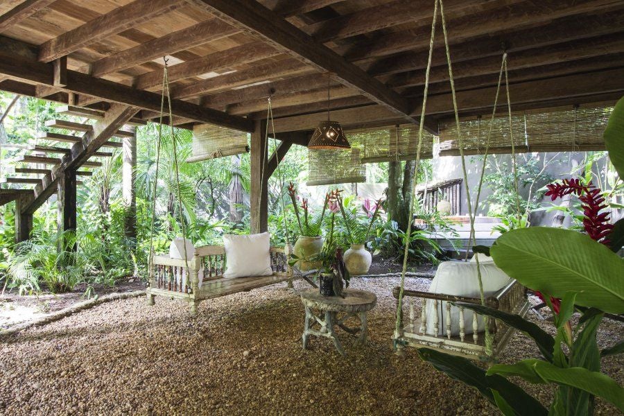 Luxurious treehouse-style suite at UXUA Casa Hotel and Spa in Trancoso, Brazil, with rustic wood design and lush tropical greenery surrounding the elevated wooden deck