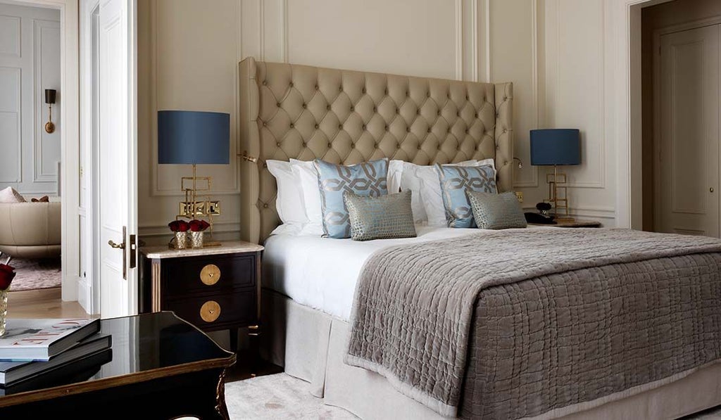 Luxurious Knightsbridge Suite with plush king bed, elegant marble bathroom, panoramic city view, and sophisticated neutral color palette in prestigious London hotel