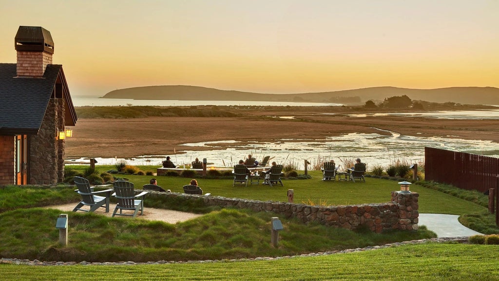 Luxurious coastal lodge nestled among pine trees with panoramic views of Bodega Bay, featuring rustic wood architecture and serene ocean landscape