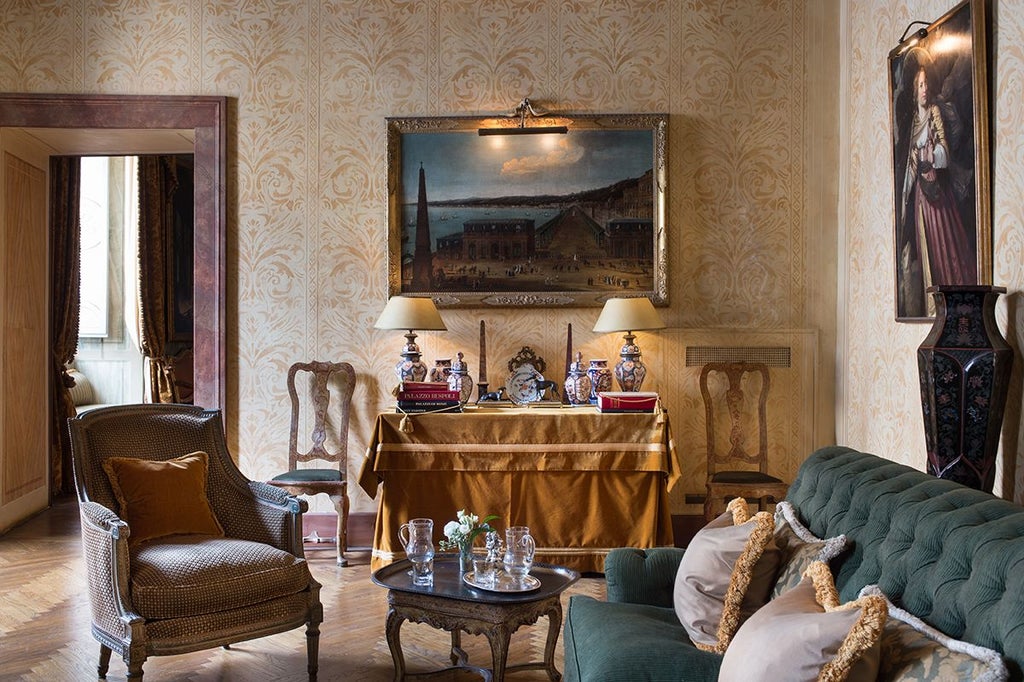 Opulent historic suite with ornate gold-framed mirrors, rich burgundy velvet chairs, and intricate baroque-style decor in Roman luxury hotel room