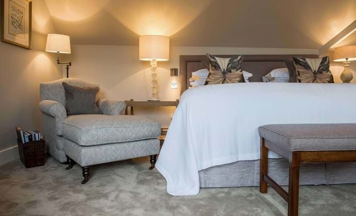 Elegant estate room with sophisticated decor, plush king-sized bed, contemporary furnishings, and warm neutral tones at luxury Scenset hotel spa retreat