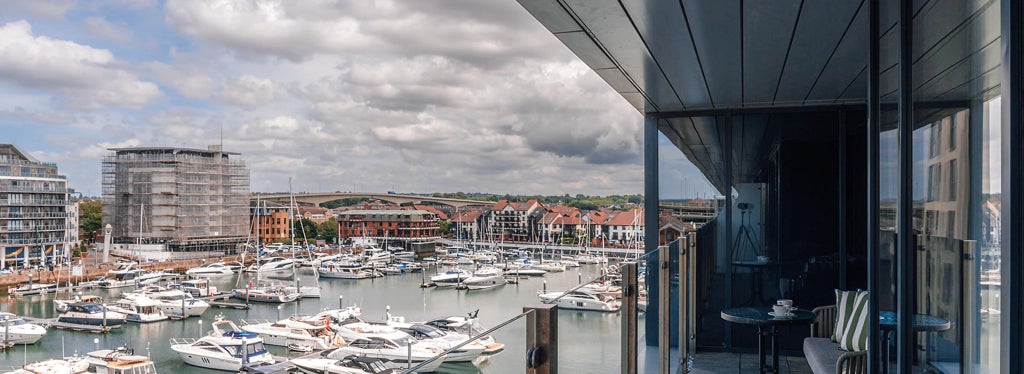 Spacious Marina View Suite with private balcony overlooking Southampton's waterfront, featuring contemporary furnishings and elegant maritime-inspired design