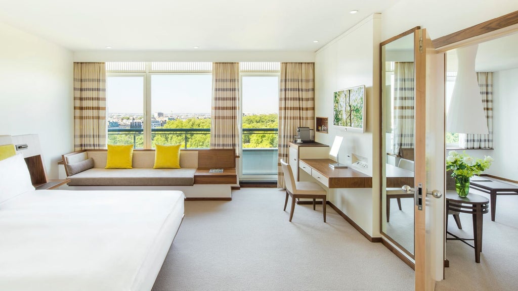 Elegant COMO Suite at COMO Metropolitan London, featuring modern minimalist design with crisp white linens, neutral tones, and city skyline view
